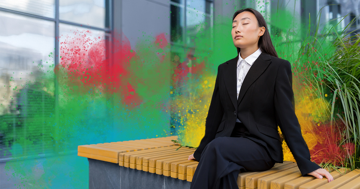 Person sitting on a bench outside an office, practicing mindfulness with eyes closed, stress management for DiSC styles