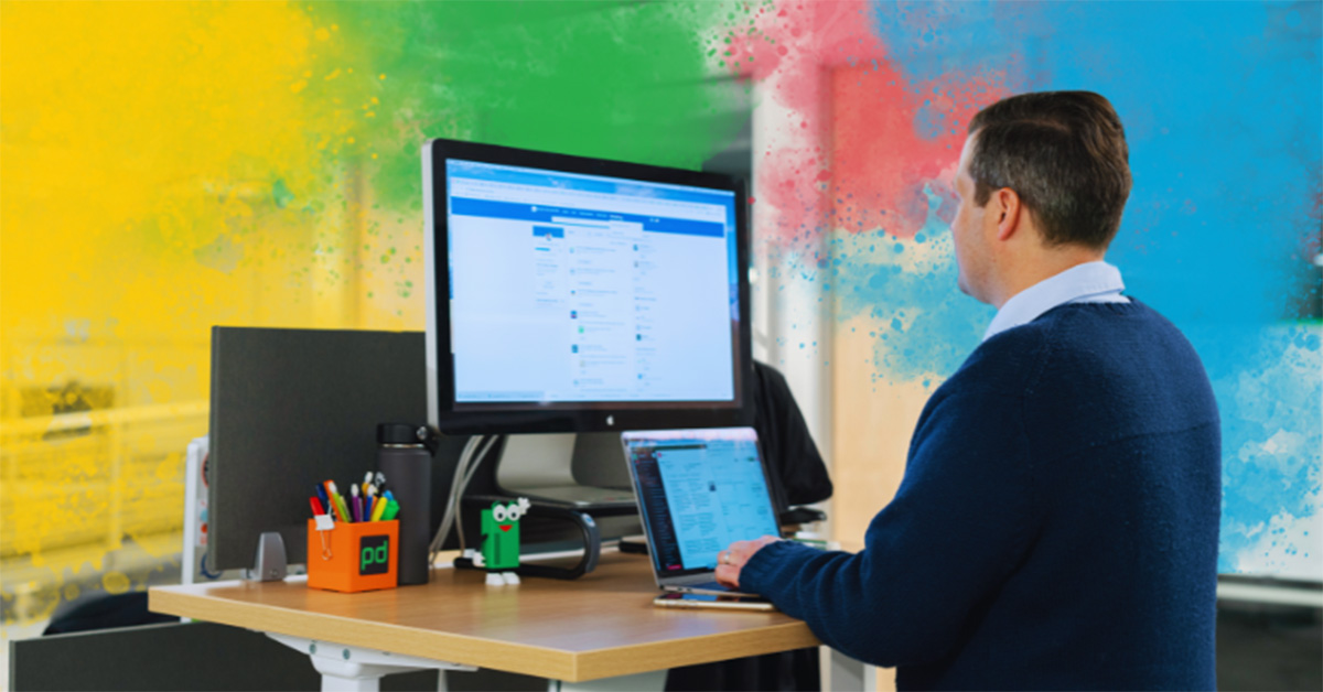 Image of a man standing at his desk and networking on LinkedIn